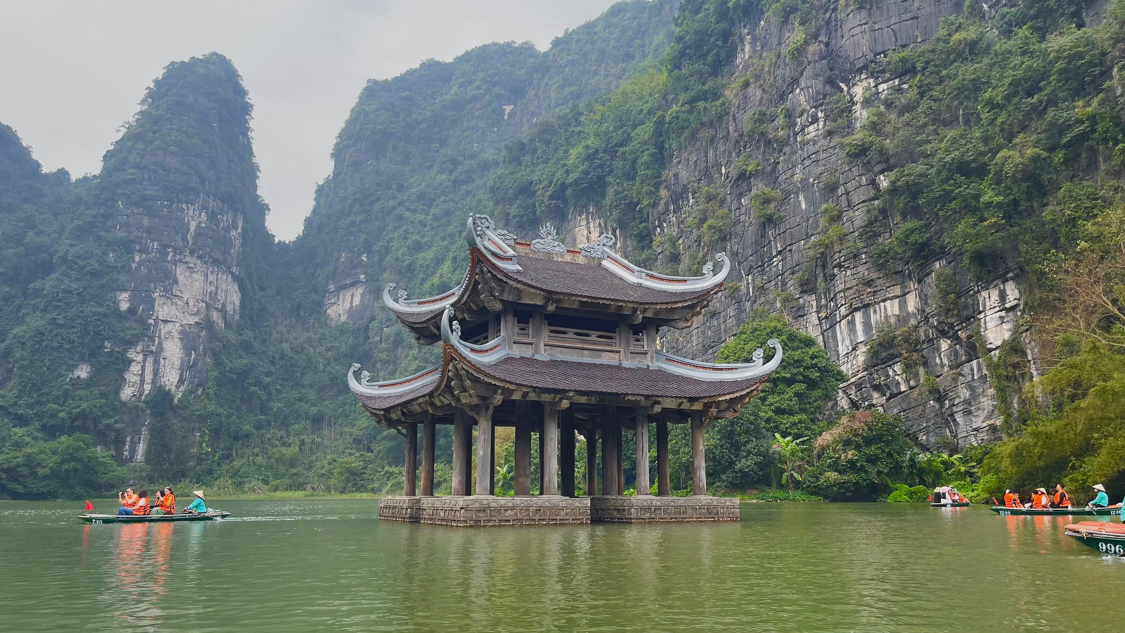 A lake held between limestone mountains at Tuyệt Tình Cốc, Ninh Bình.