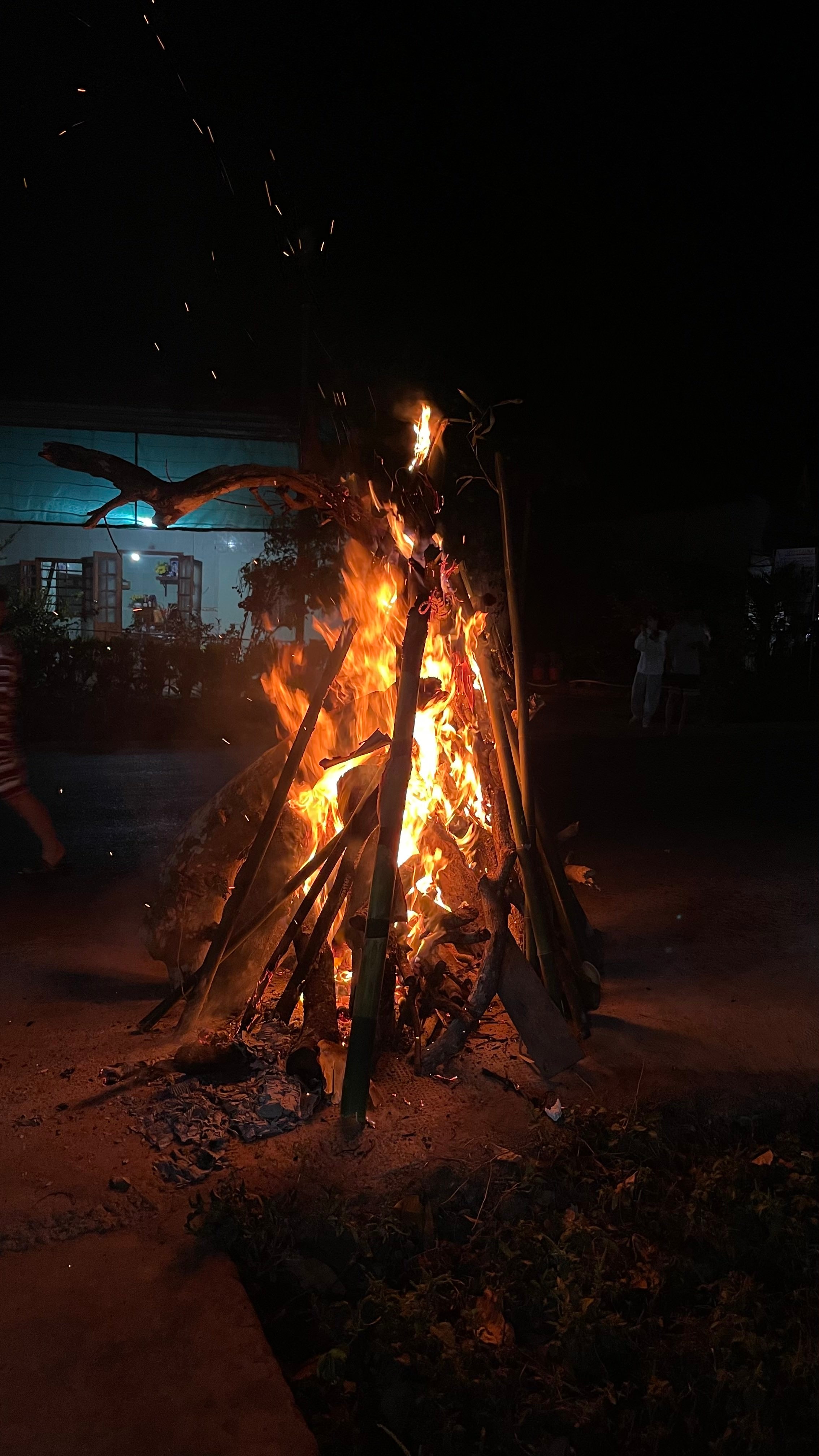 A bamboo bonfire burning at night during Tết.