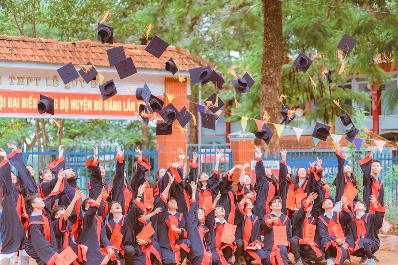 A high-school class tossing caps during a yearbook photoshoot.