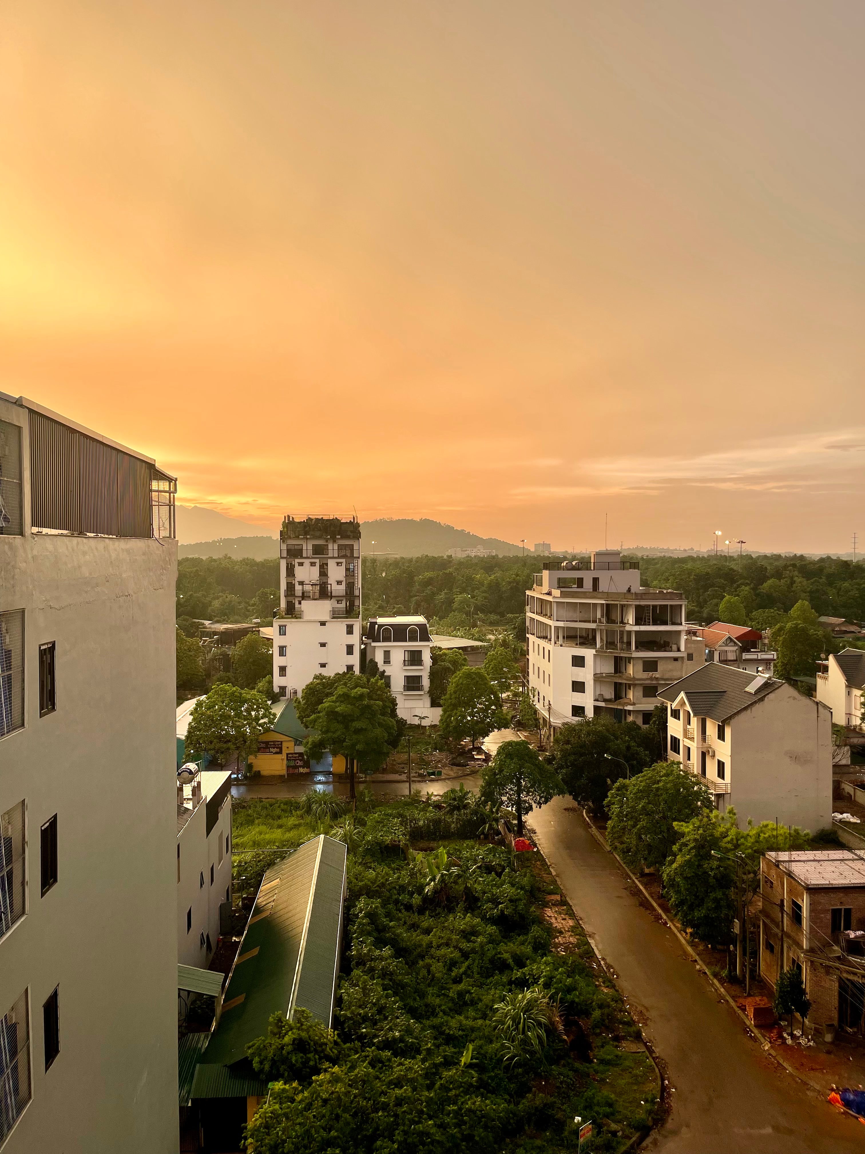 Sunset sky photographed from a window in a Hanoi room.