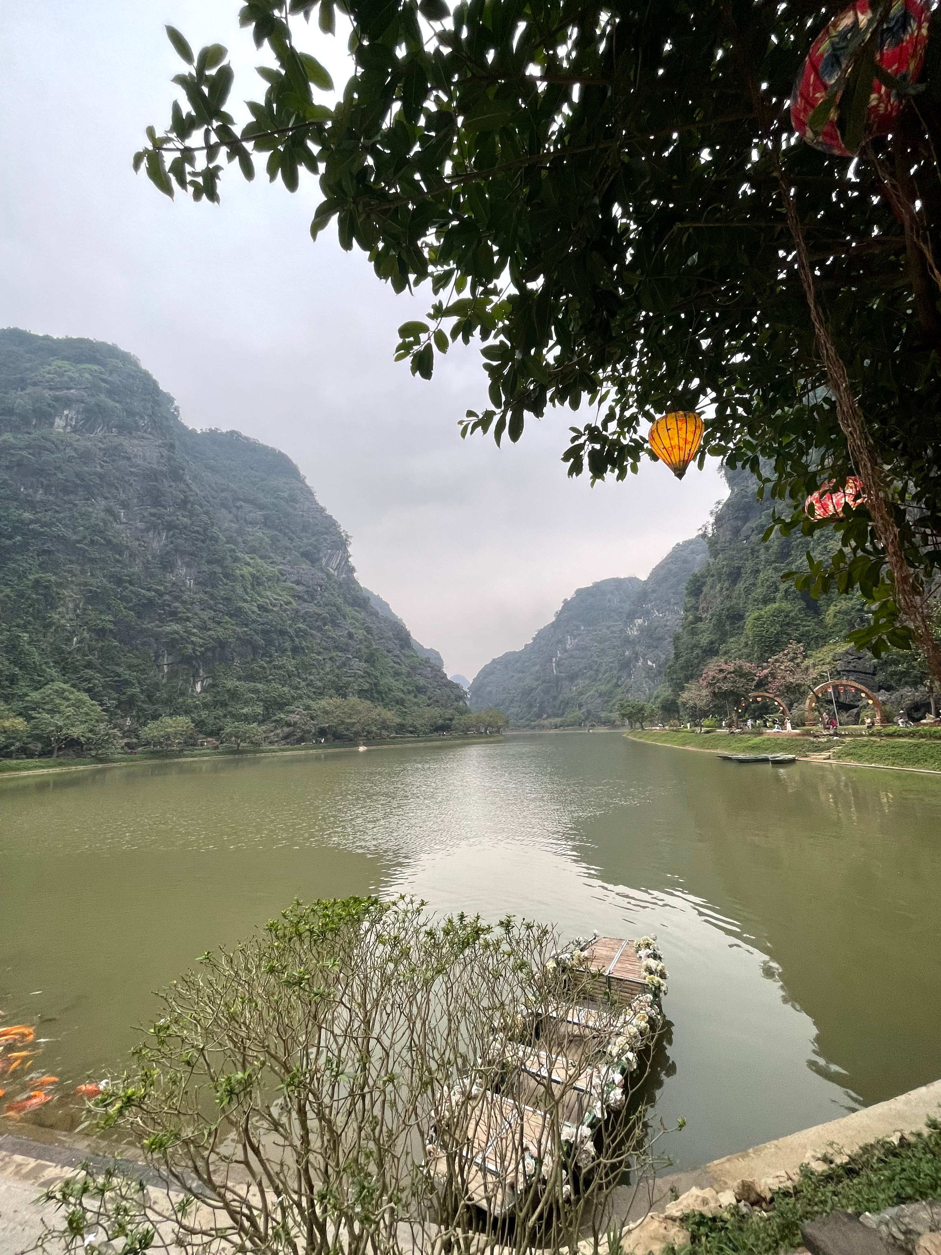 A lake surrounded by limestone mountains at Tuyệt Tình Cốc, Ninh Bình.